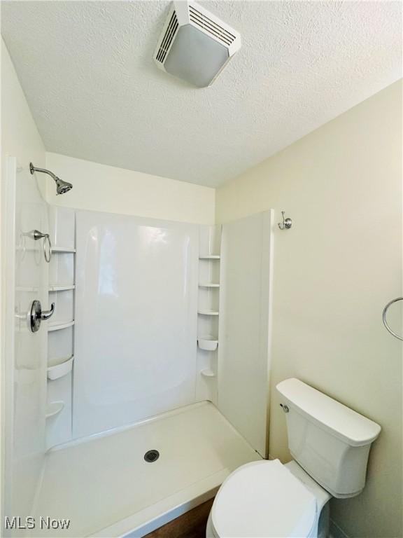 1019 Trenton, Toronto, OH 43964 - bathroom featuring a stall shower, visible vents, a textured ceiling, and toilet