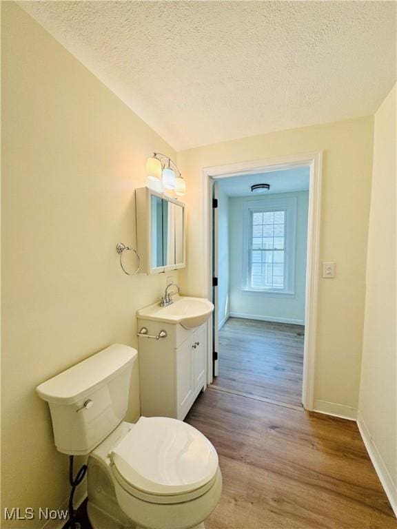 1019 Trenton, Toronto, OH 43964 - bathroom with a textured ceiling, toilet, wood finished floors, vanity, and baseboards