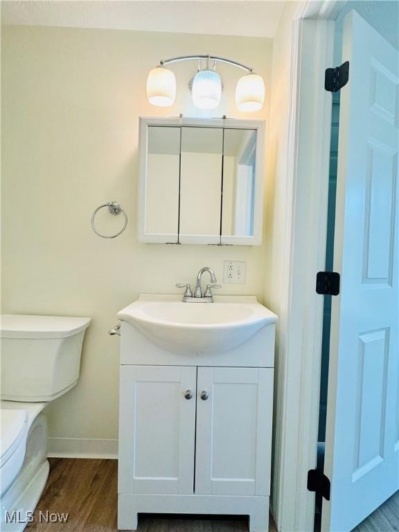 1019 Trenton, Toronto, OH 43964 - bathroom featuring toilet, baseboards, wood finished floors, and vanity