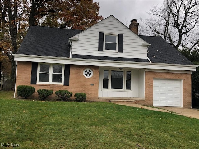 view of front facade with a garage, a shingled roof, a chimney, a front yard, and brick siding