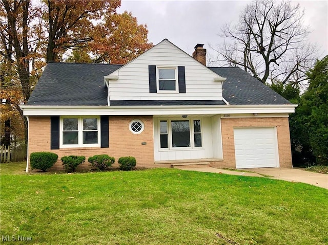 view of front of property with a front yard, brick siding, a chimney, and an attached garage