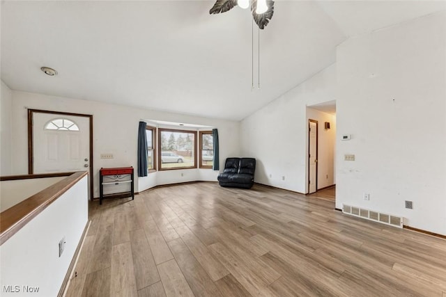 unfurnished room with light wood-type flooring, high vaulted ceiling, visible vents, and a ceiling fan