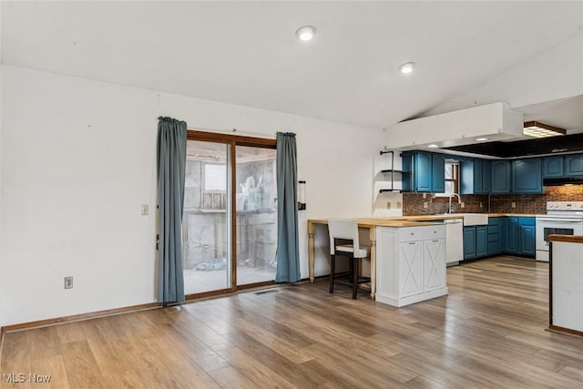 kitchen with white appliances, wood finished floors, blue cabinetry, backsplash, and exhaust hood