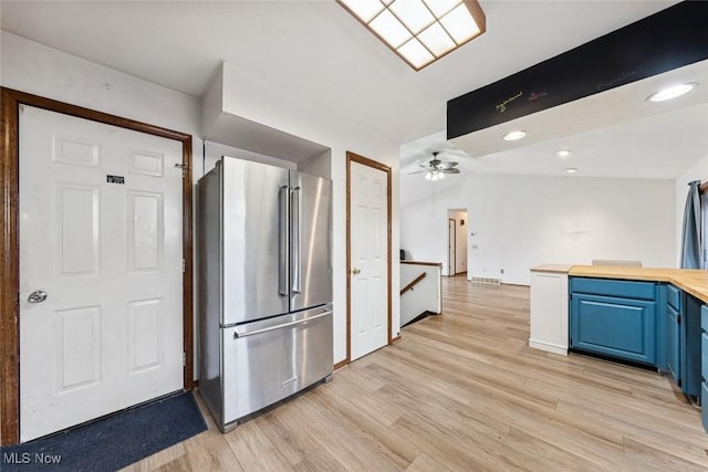 kitchen featuring ceiling fan, wood counters, blue cabinets, light wood-type flooring, and high end refrigerator