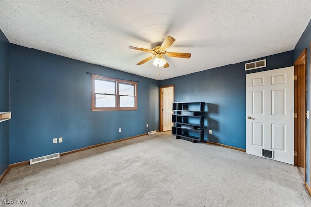 unfurnished bedroom featuring a textured ceiling, carpet, visible vents, and baseboards