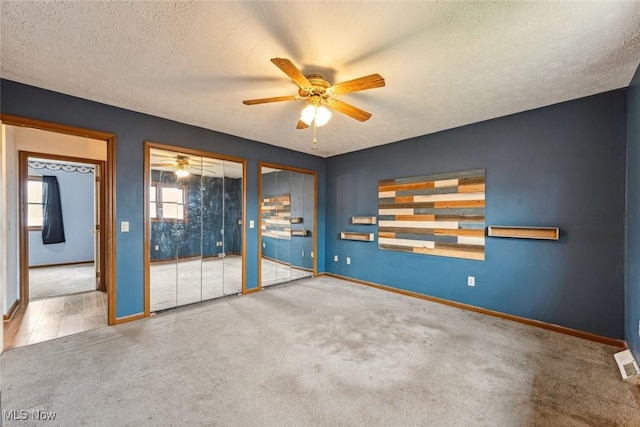 carpeted spare room with a ceiling fan, a textured ceiling, and baseboards