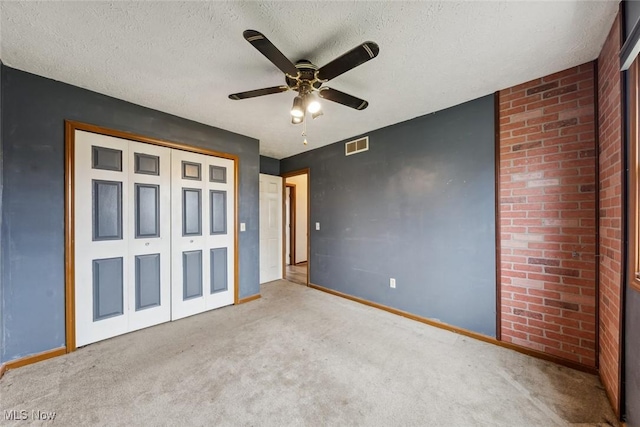 unfurnished bedroom featuring a textured ceiling, carpet floors, and visible vents