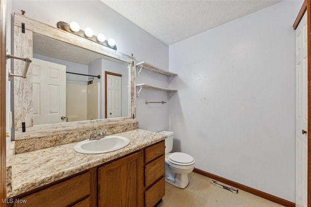 bathroom with a textured ceiling, toilet, visible vents, vanity, and baseboards