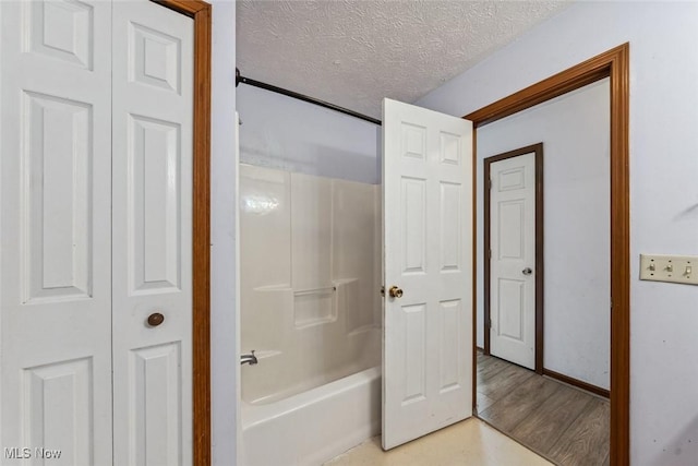 full bath featuring a closet, a textured ceiling, and wood finished floors