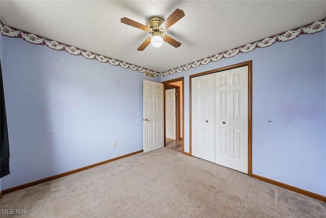 unfurnished bedroom featuring a closet, visible vents, carpet flooring, a textured ceiling, and baseboards