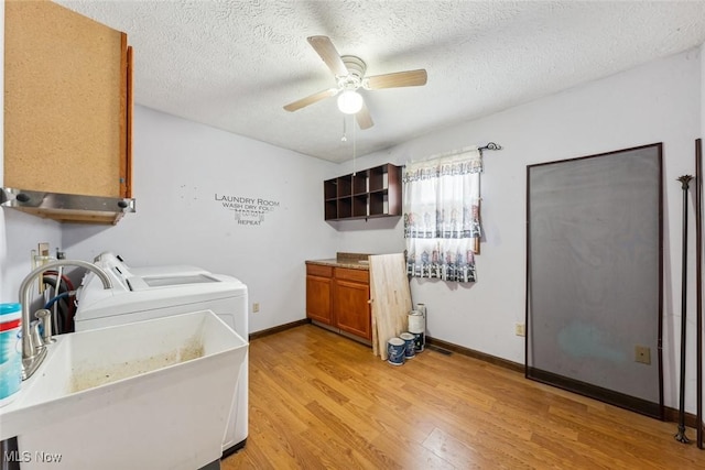 laundry area featuring laundry area, washer and clothes dryer, a ceiling fan, light wood-style floors, and a sink