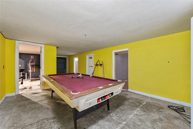 game room featuring concrete flooring, pool table, a textured ceiling, and baseboards