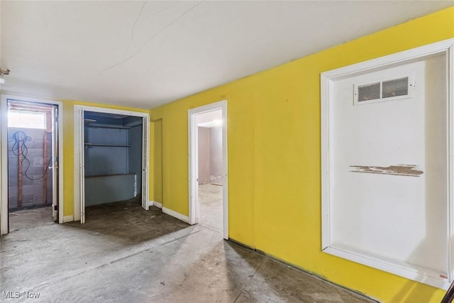 interior space with baseboards, visible vents, and concrete flooring