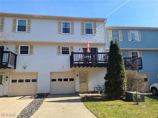 multi unit property featuring a garage, driveway, and central AC unit