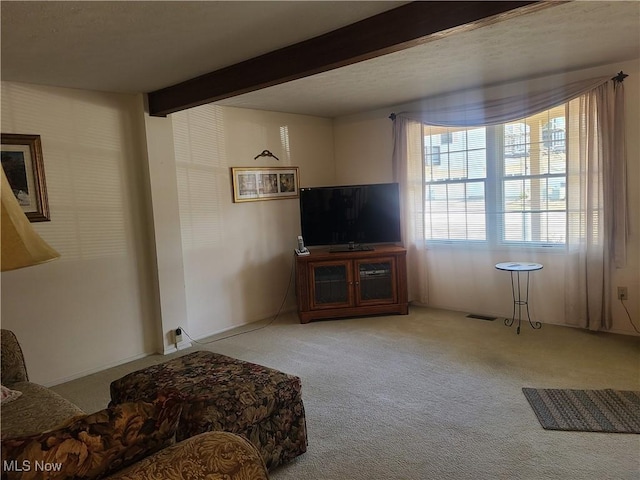 living area with beam ceiling and carpet flooring