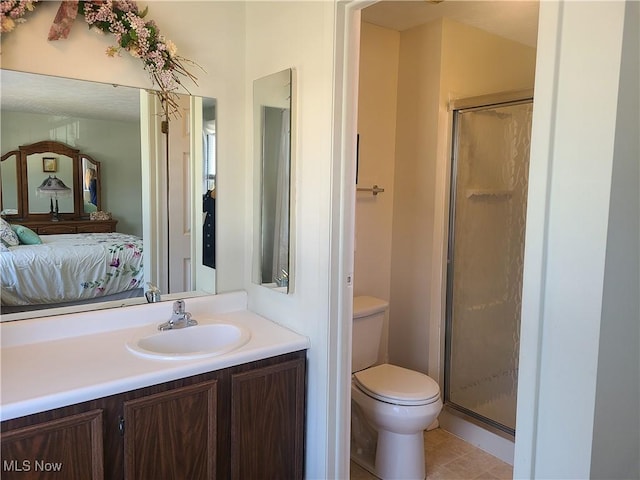 ensuite bathroom with toilet, a stall shower, vanity, and ensuite bathroom