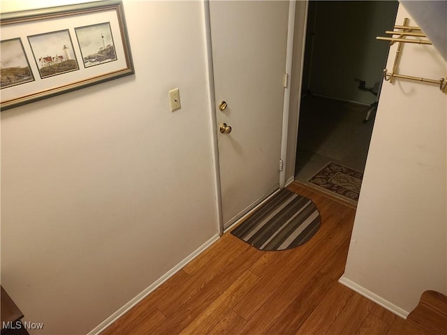 hall featuring wood finished floors and baseboards