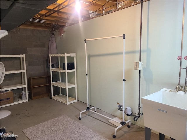 workout room featuring concrete block wall and a sink