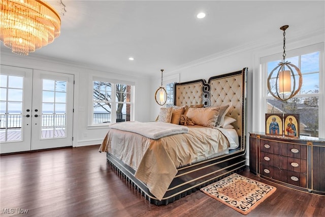bedroom featuring an inviting chandelier, dark wood finished floors, crown molding, french doors, and access to outside