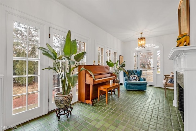 sitting room with a tiled fireplace and a notable chandelier