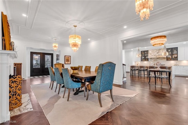 dining room with a chandelier, recessed lighting, ornamental molding, and a premium fireplace