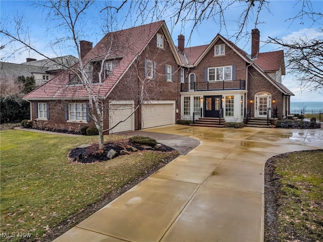 view of front facade with a chimney, brick siding, an attached garage, french doors, and concrete driveway