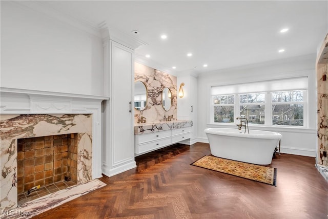 full bath with a freestanding tub, vanity, ornamental molding, and recessed lighting