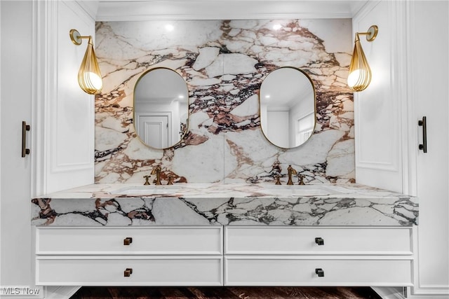 bathroom featuring crown molding, double vanity, and a sink