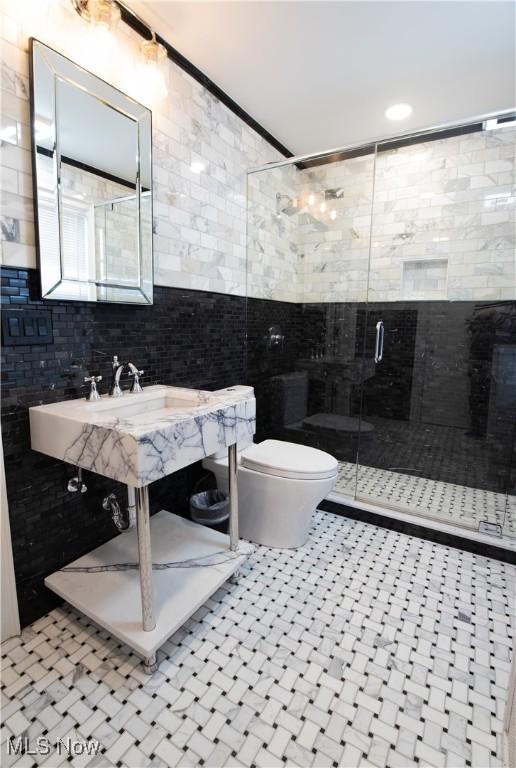 full bath with toilet, a stall shower, tasteful backsplash, and tile walls