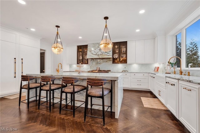 kitchen with decorative backsplash, white cabinetry, custom range hood, and glass insert cabinets