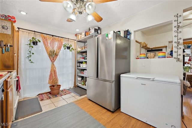 kitchen with open shelves, light countertops, a ceiling fan, freestanding refrigerator, and white fridge