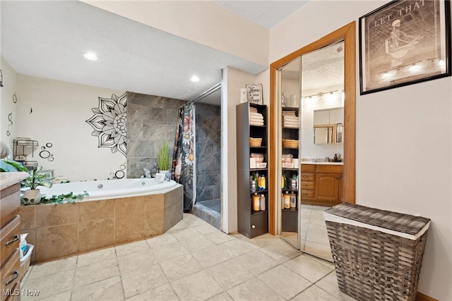 bathroom featuring recessed lighting, a tile shower, a bath, and vanity