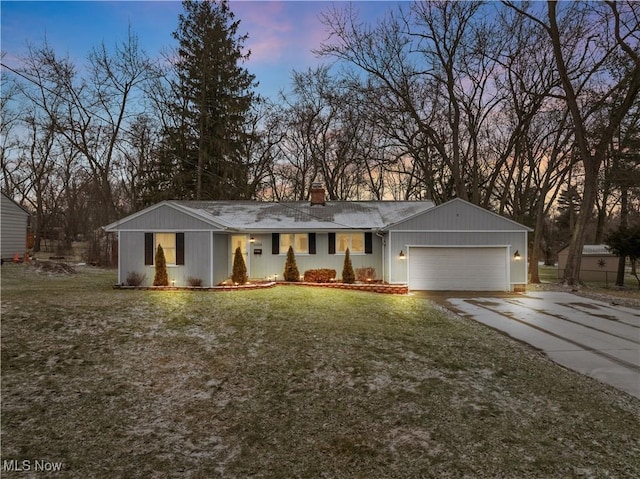 ranch-style house with concrete driveway, a lawn, a chimney, and an attached garage