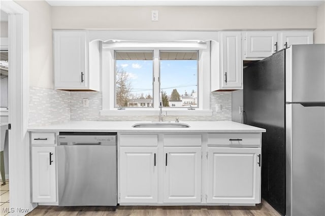 kitchen featuring appliances with stainless steel finishes, white cabinetry, and a sink