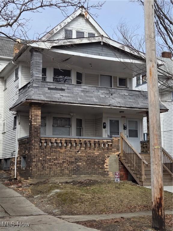 view of front of home featuring a porch, stairway, and a balcony