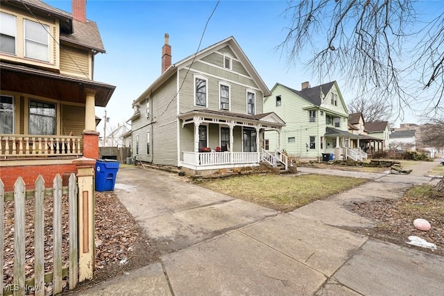 view of front facade featuring a chimney and a porch