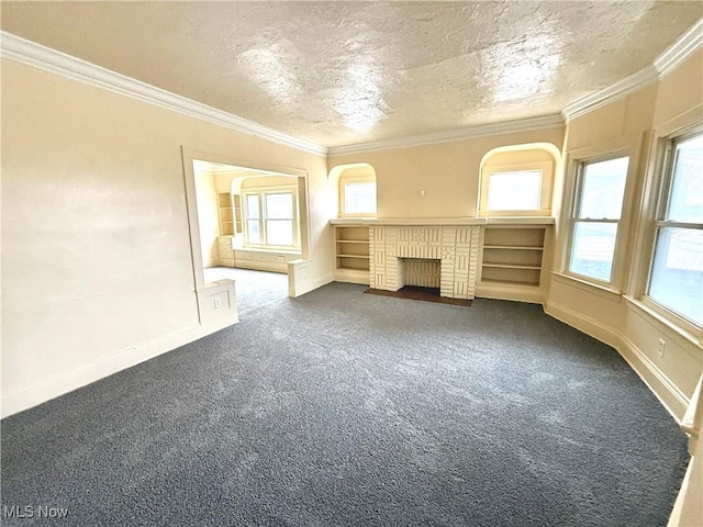 unfurnished living room with baseboards, ornamental molding, dark colored carpet, a textured ceiling, and a brick fireplace