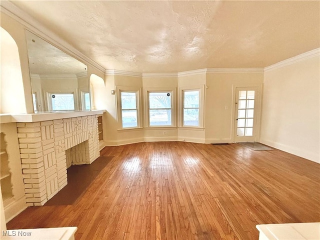 interior space with ornamental molding, arched walkways, and hardwood / wood-style floors