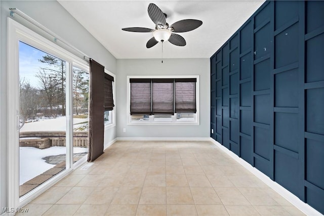 unfurnished sunroom featuring ceiling fan