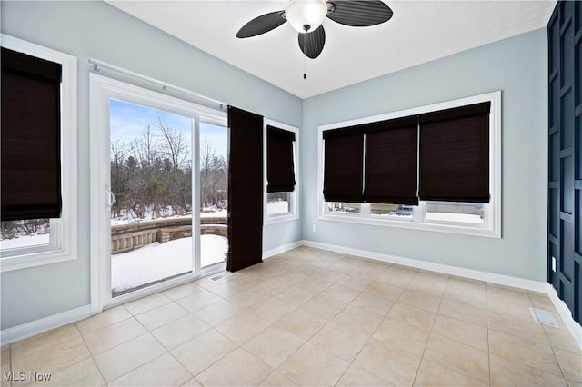 unfurnished room featuring a ceiling fan, visible vents, baseboards, and light tile patterned floors