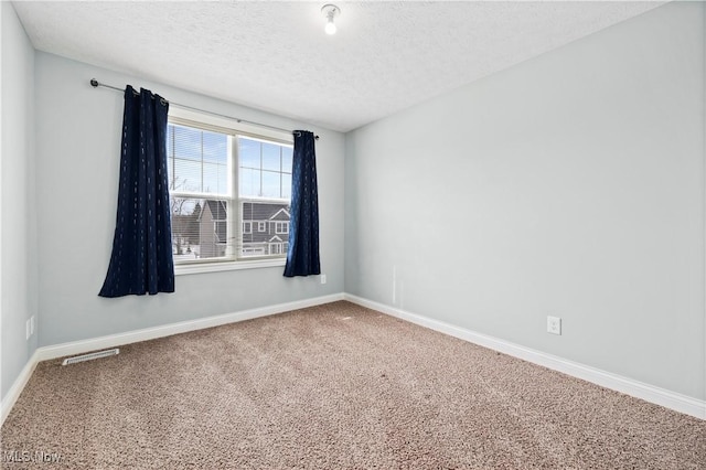 carpeted empty room with a textured ceiling, visible vents, and baseboards