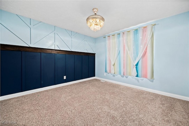 carpeted spare room featuring visible vents and baseboards