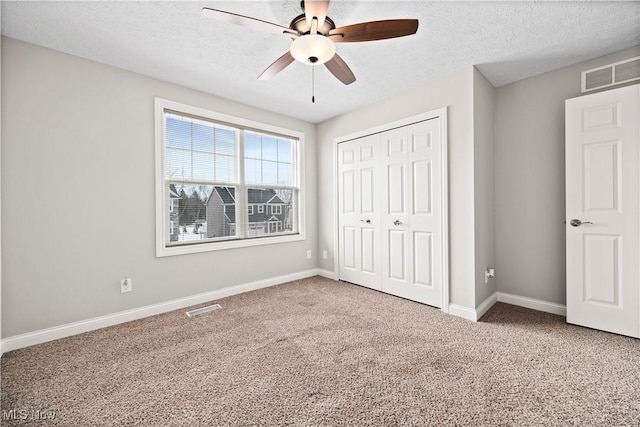 unfurnished bedroom with a closet, carpet, and visible vents