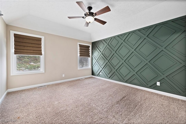 spare room with an accent wall, plenty of natural light, carpet flooring, and baseboards