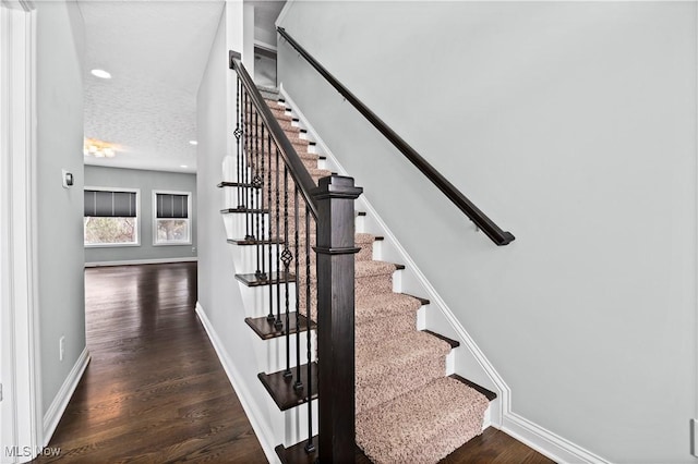 stairs featuring recessed lighting, a textured ceiling, baseboards, and wood finished floors