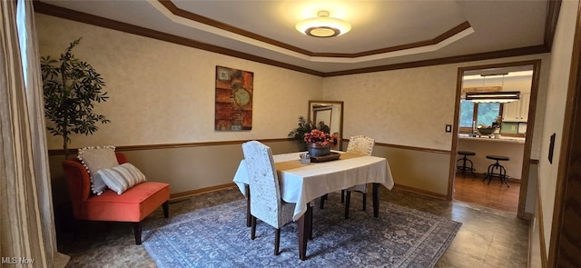 dining room featuring baseboards, a tray ceiling, and ornamental molding