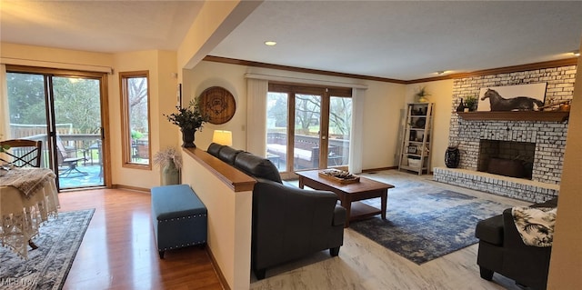 living area featuring a brick fireplace, baseboards, and crown molding