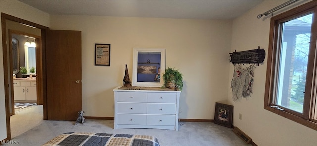 bedroom featuring light carpet, multiple windows, and baseboards