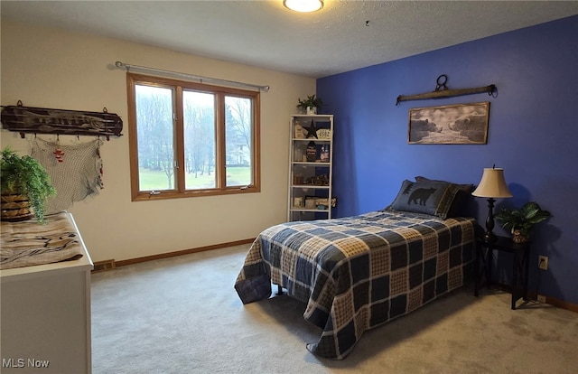 bedroom with a textured ceiling, baseboards, and carpet flooring