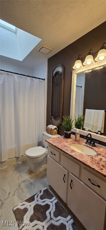 full bathroom with a skylight, vanity, and toilet